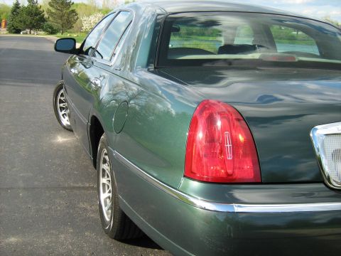 1988 Mercury Grand Marquis - The rear taillight assembly of a green sedan is visible, with a chrome accent strip below it.