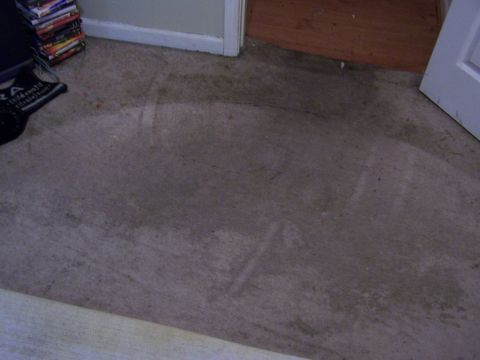 1978 Ford Bronco - A water heater is visible on a carpeted floor, with a stack of DVDs in the background.