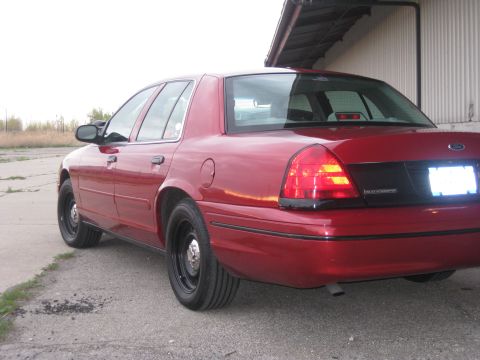 2000 Ford Crown Victoria - Rear quarter view of a red 2000 Ford Crown Victoria, showing its distinctive body style and taillights.