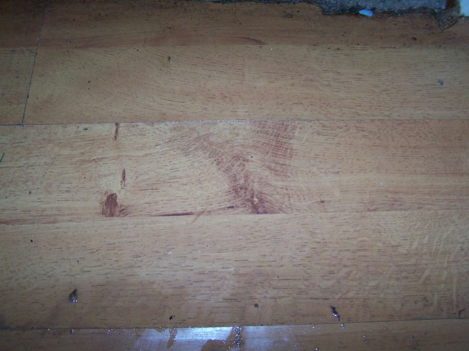 Wooden floor with visible grain and some debris