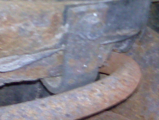 Close-up of heavily rusted metal components, possibly from a vehicle's undercarriage
