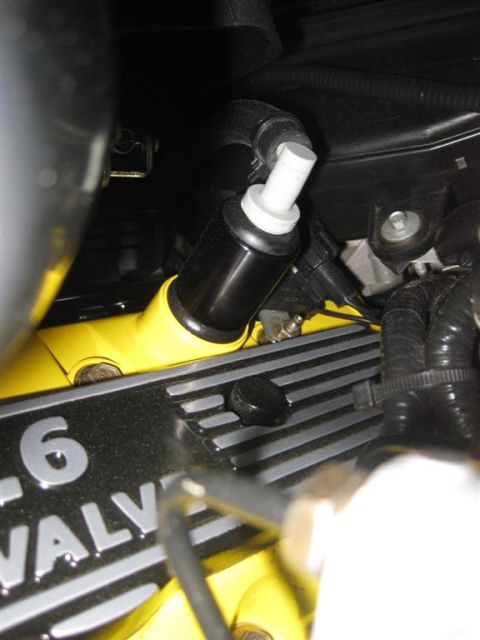 2003 Mercury Marauder - Close-up of an engine component, possibly an oil separator, attached to a yellow intake manifold and a black valve cover with '6 VALVE' tex…