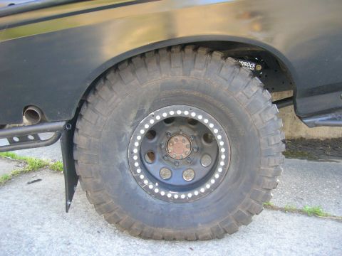 1996 Ford Bronco - Rear wheel and fender detail of a 1996 Ford Bronco, showing off-road modifications.