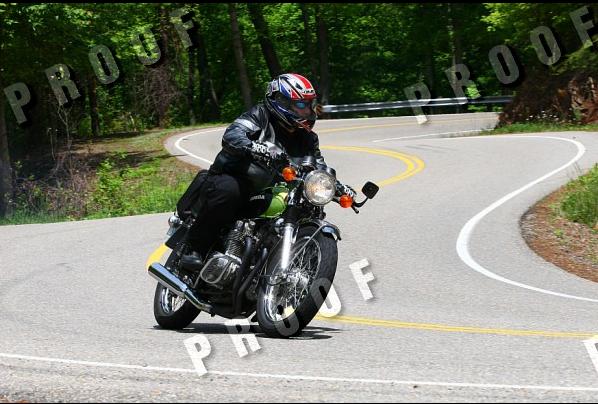 Green motorcycle with chrome accents on a winding road