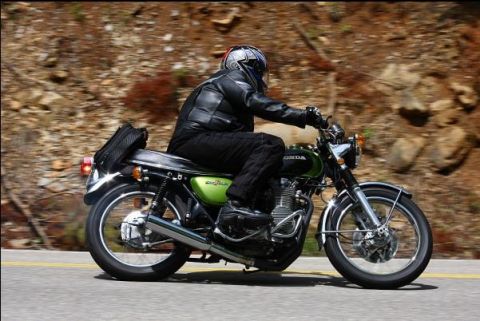 1985 Ford LTD Crown Victoria - Motorcyclist on a green Honda cruising down a scenic road.