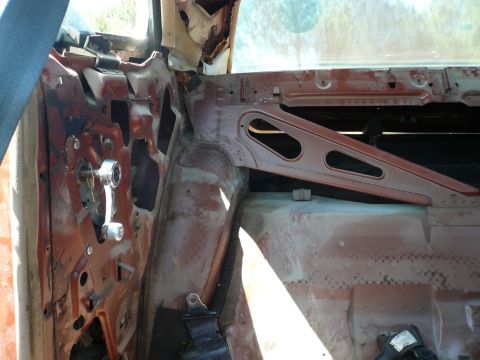 1975 Ford Ranchero - Close-up view of the interior door panel, showing the window crank mechanism and rusted metal components.
