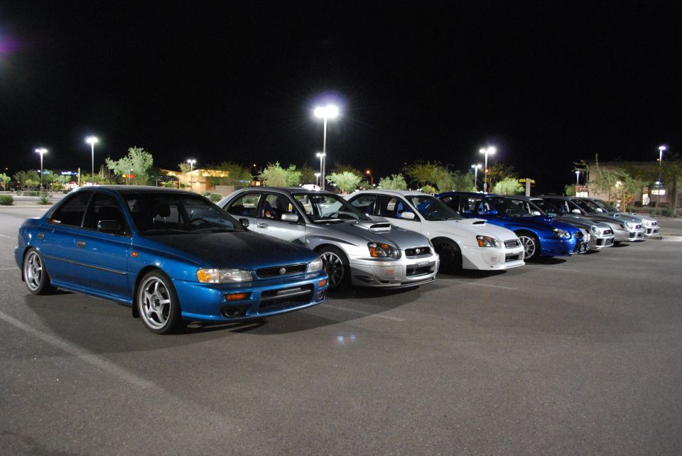 Blue 2005 Subaru Impreza sedan in a line of similar cars at night