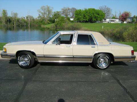 1988 Mercury Grand Marquis - This 1988 Mercury Grand Marquis is shown from the side, parked outdoors with a body of water in the background.