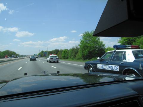 1991 Ford LTD Crown Victoria - From inside a car, a black-and-white North Haven Police sedan with blue light bar rides alongside on a multi-lane highway.