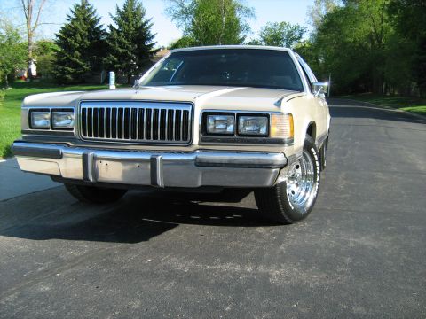 1988 Mercury Grand Marquis - Front view of a 1988 Mercury Grand Marquis with a prominent chrome grille and custom wheels.