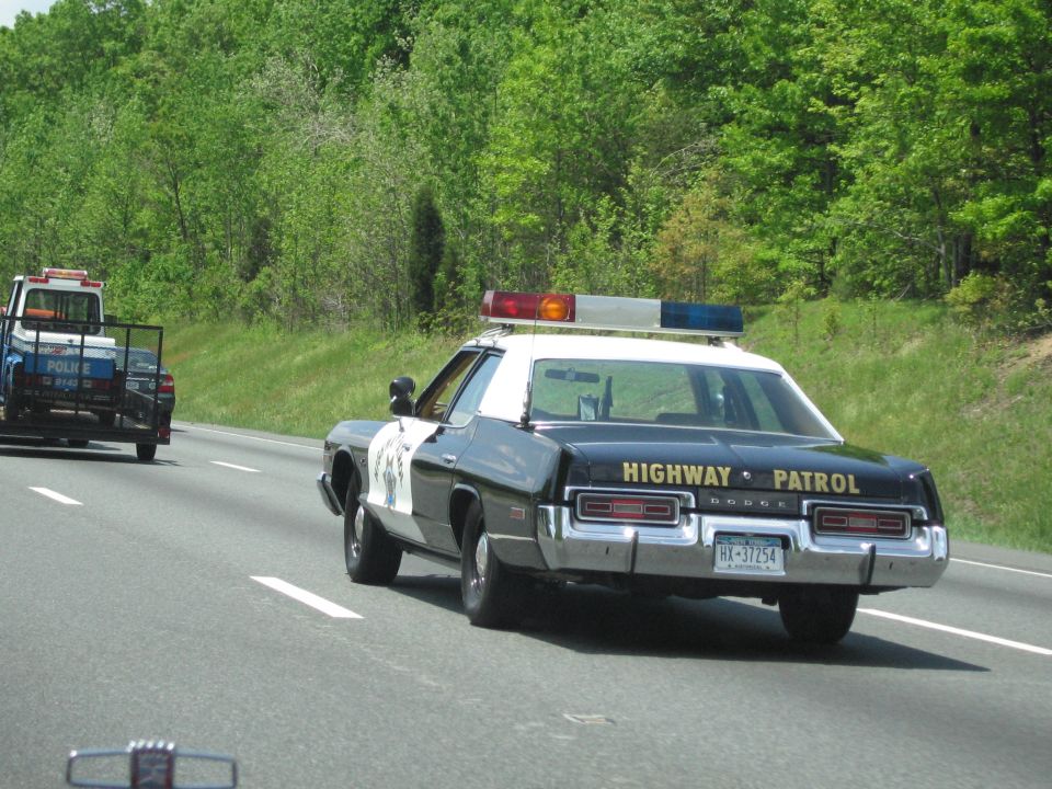 Rear of black-and-white Dodge Highway Patrol sedan on the highway