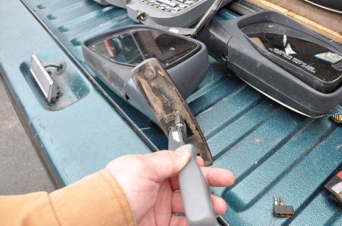 1996 Ford Bronco - Side mirrors are shown on a teal truck bed, with one mirror being worked on.