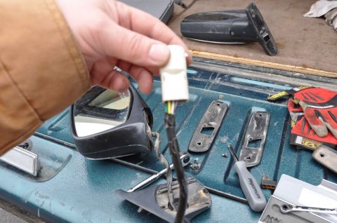 1996 Ford Bronco - Disassembled side mirror components and wiring laid out on a truck bed, ready for repair or replacement.
