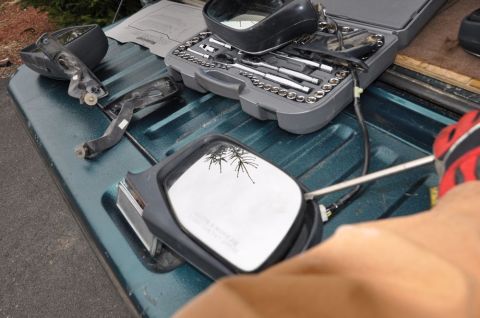 1996 Ford Bronco - Working on car mirrors with tools laid out on a truck bed.