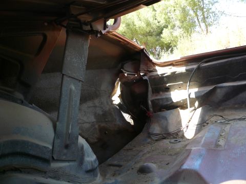 1975 Ford Ranchero - The interior of a vehicle bed shows significant rust and damage, with exposed wiring visible.