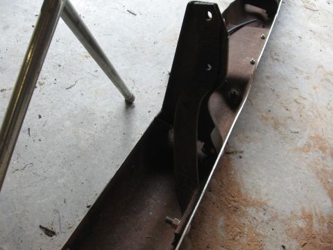 1966 Ford F-100 - Rusty metal bracket with bolts on a concrete floor.