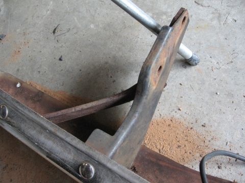 1966 Ford F-100 - Close-up of a corroded bumper bracket and chrome trim piece on a concrete surface.