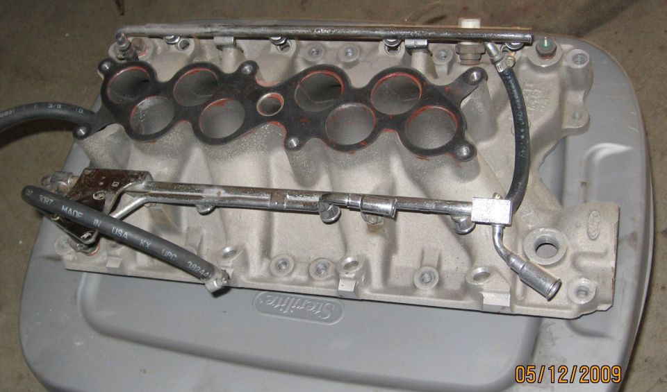 Ford cast-aluminum lower intake manifold with fuel rails removed on a tote lid