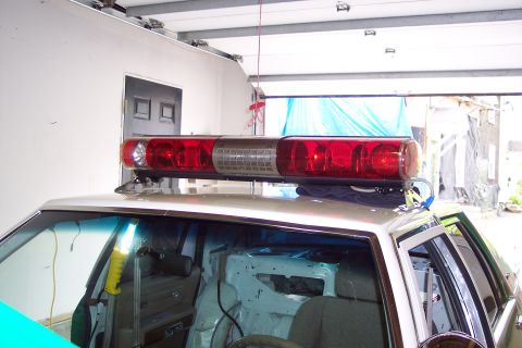2001 Ford Crown Victoria - Interior of a white 2001 Ford Crown Victoria police car with its light bar visible from the exterior.