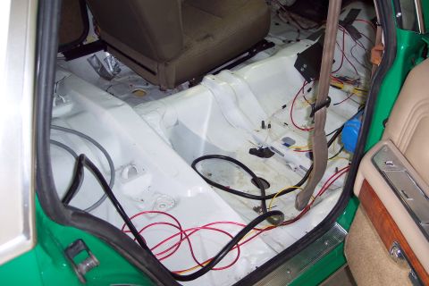 2001 Ford Crown Victoria - The interior of a car is shown with seats removed and wiring exposed.