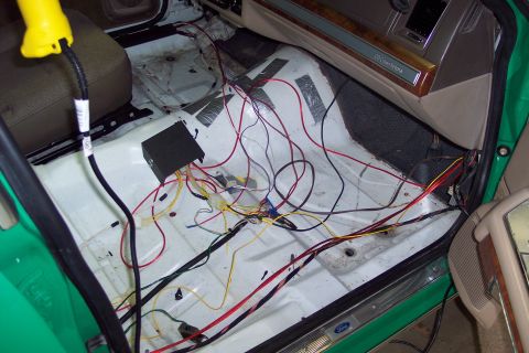 2001 Ford Crown Victoria - The interior of a 2001 Ford Crown Victoria shows extensive exposed wiring and a black control box, indicating custom modifications or repai…