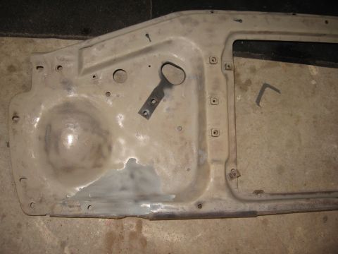 1966 Ford F-100 - This image shows the underside of a vehicle hood, likely undergoing preparation for painting, with visible primer and areas of body filler.