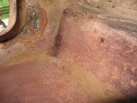 1966 Ford F-100 - This image shows heavily rusted metal with visible weld marks, suggesting it's part of a vehicle's interior structure.