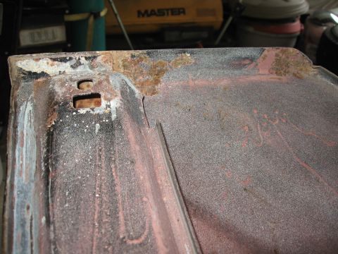 1966 Ford F-100 - Close-up of a weathered metal panel, likely a vehicle part, showing signs of rust and preparation for painting.