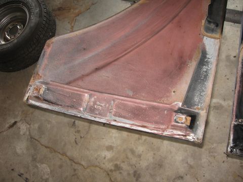 1966 Ford F-100 - A section of a truck fender, prepped for paint, sits next to a tire on a concrete floor.