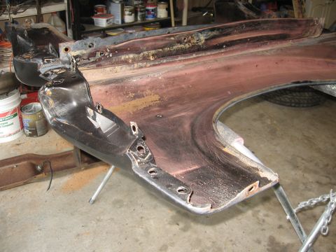 1966 Ford F-100 - A disassembled truck fender sits on a stand, showing signs of rust and preparation for a new paint job.