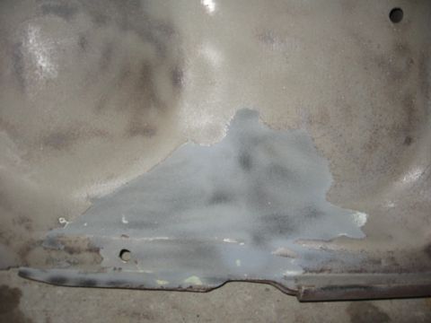 1966 Ford F-100 - Close-up of a metal panel undergoing paint preparation, revealing primer and areas of rust.