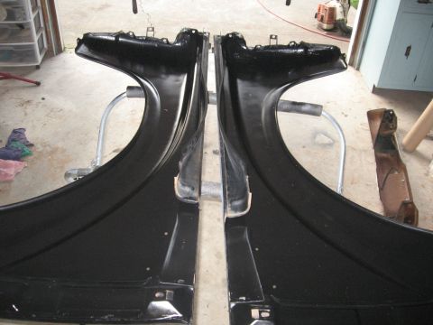 1966 Ford F-100 - Two freshly painted black fenders are displayed in a workshop setting, awaiting reinstallation.