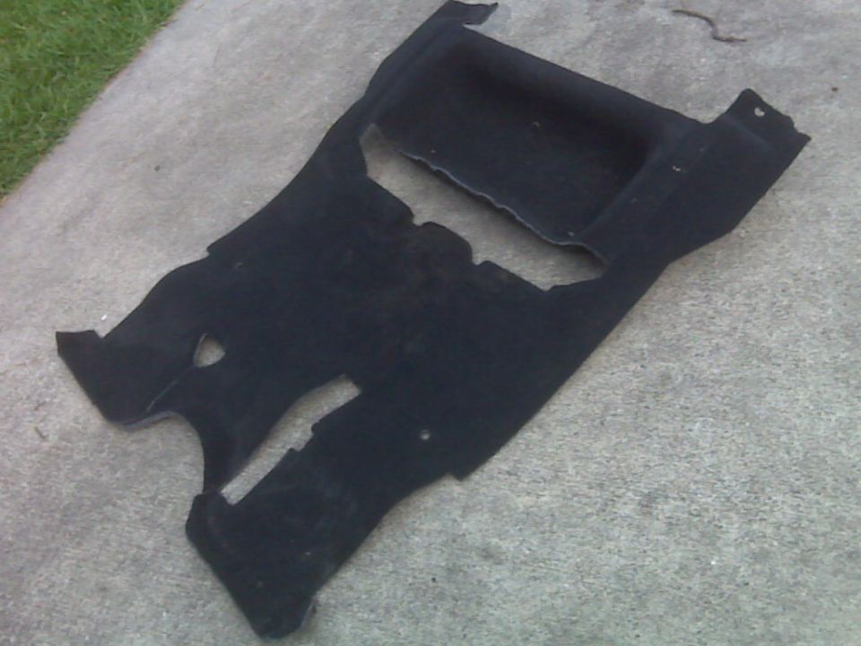 Black carpet piece with cutouts, possibly for a vehicle interior