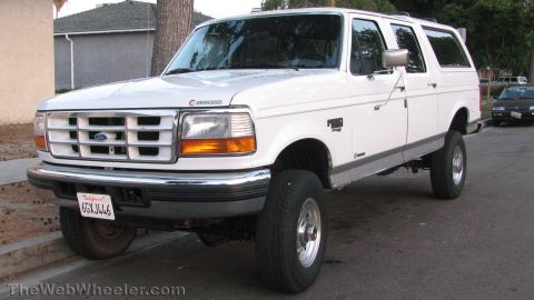 1996 Ford C-350 (Centurion Conversions) - White Ford Bronco with Centurion badging, lifted suspension, and chrome wheels.