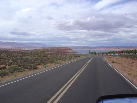 1986 Ford Bronco II - A scenic drive through a desert landscape with a lake and mountains in the distance.