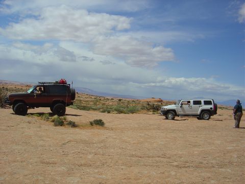 1986 Ford Bronco II - Two off-road vehicles, a classic Ford Bronco II and a modern Hummer H3, are parked in a desert landscape.