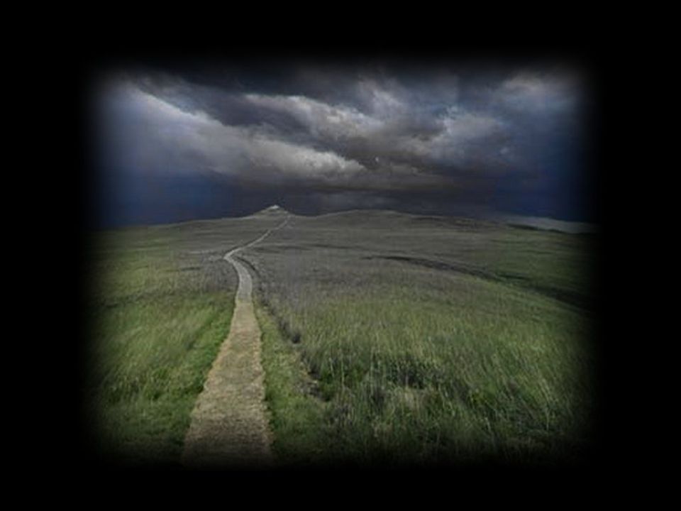 Dirt path winds through grassy hills under a stormy sky