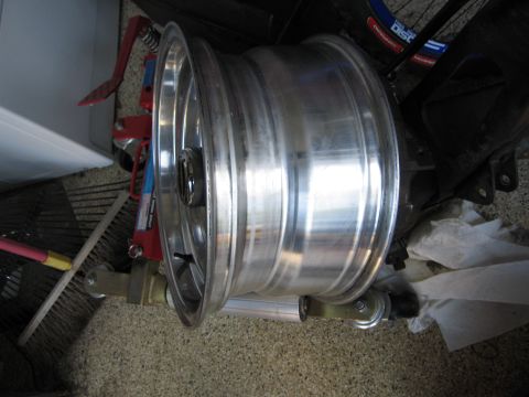 1986 Ford Bronco - A single aluminum wheel is shown, likely for a vehicle, with some tools and cleaning supplies in the background.