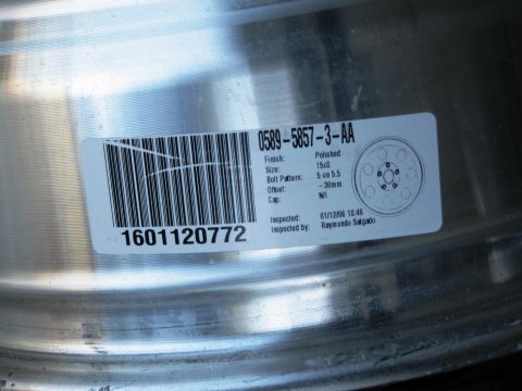 1986 Ford Bronco - Close-up of a polished aluminum wheel, detailing its specifications and inspection date.