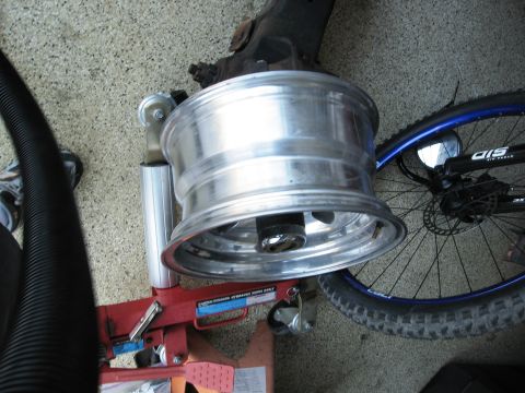 1986 Ford Bronco - Alloy wheel on a tire changing machine with a bicycle wheel to the right.