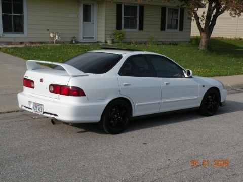 1994 Acura Integra - Rear view of a white 1994 Acura Integra sedan with a spoiler and black wheels.