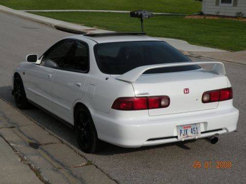 1994 Acura Integra - Rear view of a white 1994 Acura Integra sedan with a spoiler and custom wheels.
