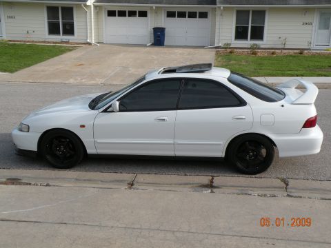 1994 Acura Integra - This white 1994 Acura Integra coupe features a prominent rear spoiler and aftermarket black wheels.