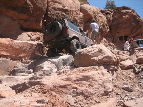 1986 Ford Bronco II - An off-road SUV tackles a challenging rocky incline, demonstrating its capability on terrain.