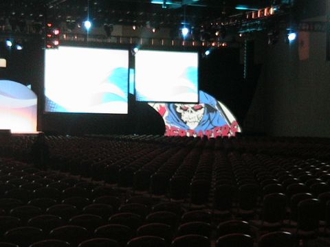 1966 Ford Bronco - An empty auditorium stage is set with large screens and a graphic, ready for an event.