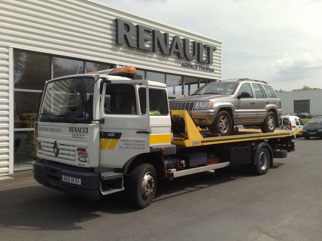 Jeep Grand Cherokee on a tow truck in front of a Renault dealership