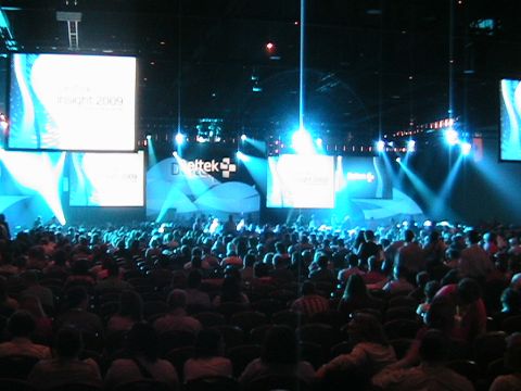 1966 Ford Bronco - A large crowd attends a conference with illuminated screens and stage lighting.