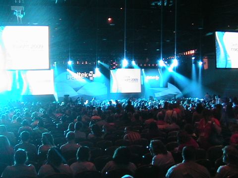 1966 Ford Bronco - A large audience attends a conference with prominent screens displaying the event's branding and year.