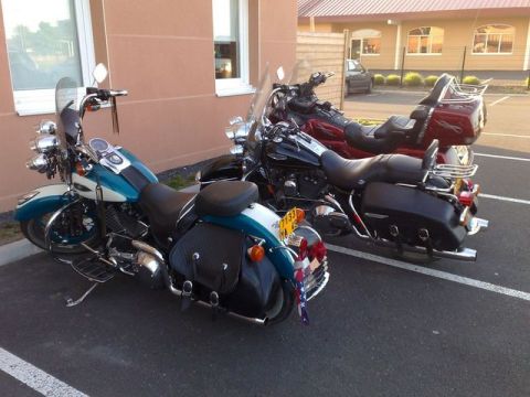 1991 Ford LTD Crown Victoria - Two motorcycles are parked side-by-side in a parking lot outside a building.