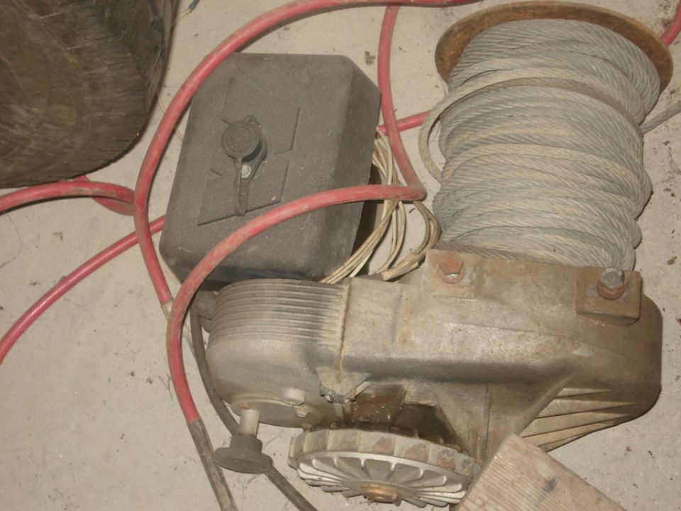 Winch with coiled cable, red hoses, and black box